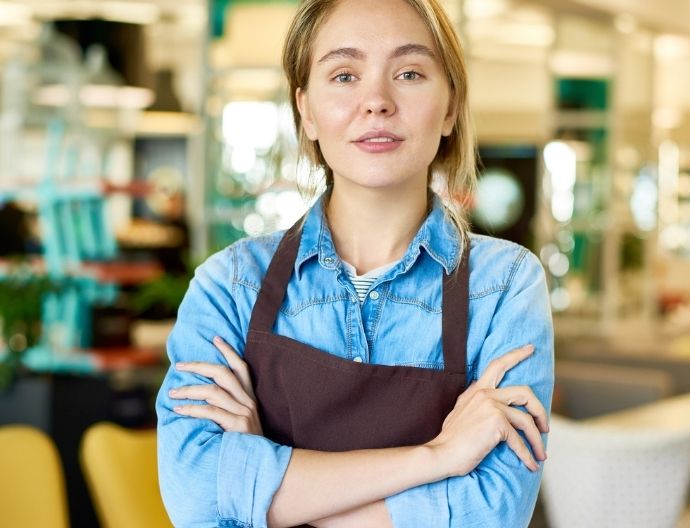 Young woman in an apron in a grocery store